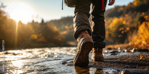 Hiking Boots Rest Near the Fall Colors Adorning the Riverbank  Inviting Adventure and Outdoor Exploration in the Vibrant Beauty of the Season