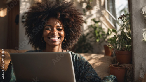 Happy mature afro american woman using a laptop while working remotely from the comfort of her home, space for tex photo