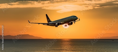 Plane flies at dusk and the sky turns yellow over the sea