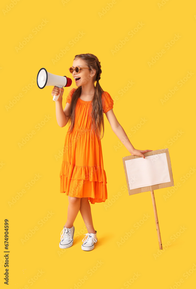 Little girl with megaphone and placard on yellow background Little girl with megaphone and placard on yellow background