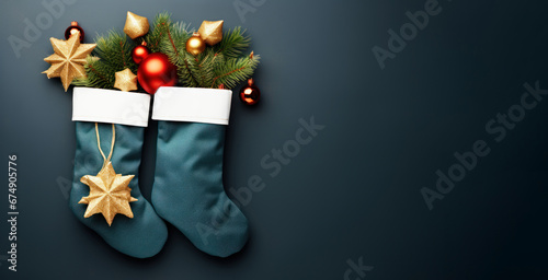 Flat lay with stockings filled with gifts and branches of Christmas tree placed on dark blue background with copy space. Three Kings Day, Epiphany day, Christmas.