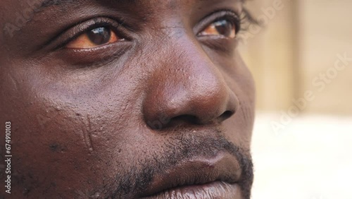 close up portrait of unhappy young african man opening his eyes looking ahead photo