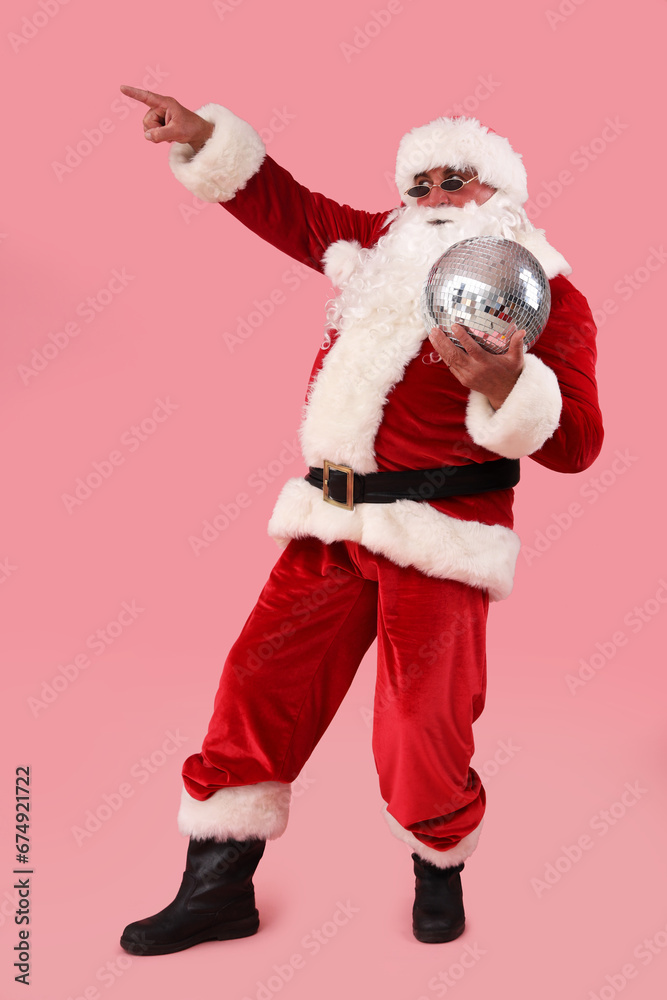 Cool Santa Claus with disco ball pointing at something on pink background