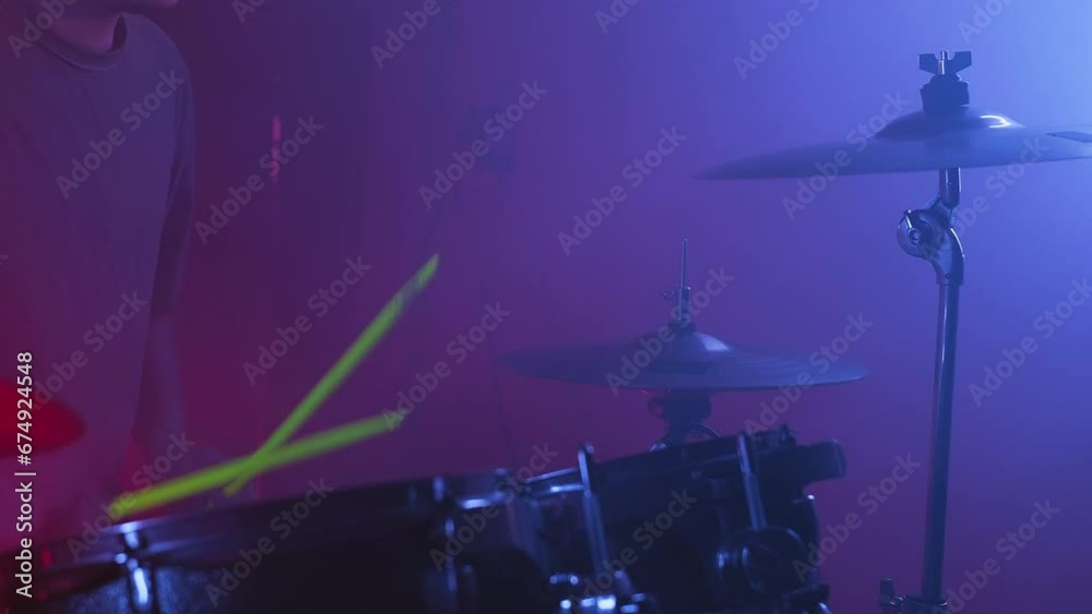 Close-up of the drummer playing the drums in the recording studio. Music band having rehearsal Close-up of the drummer playing the drums in the recording studio. Music band having rehearsal
