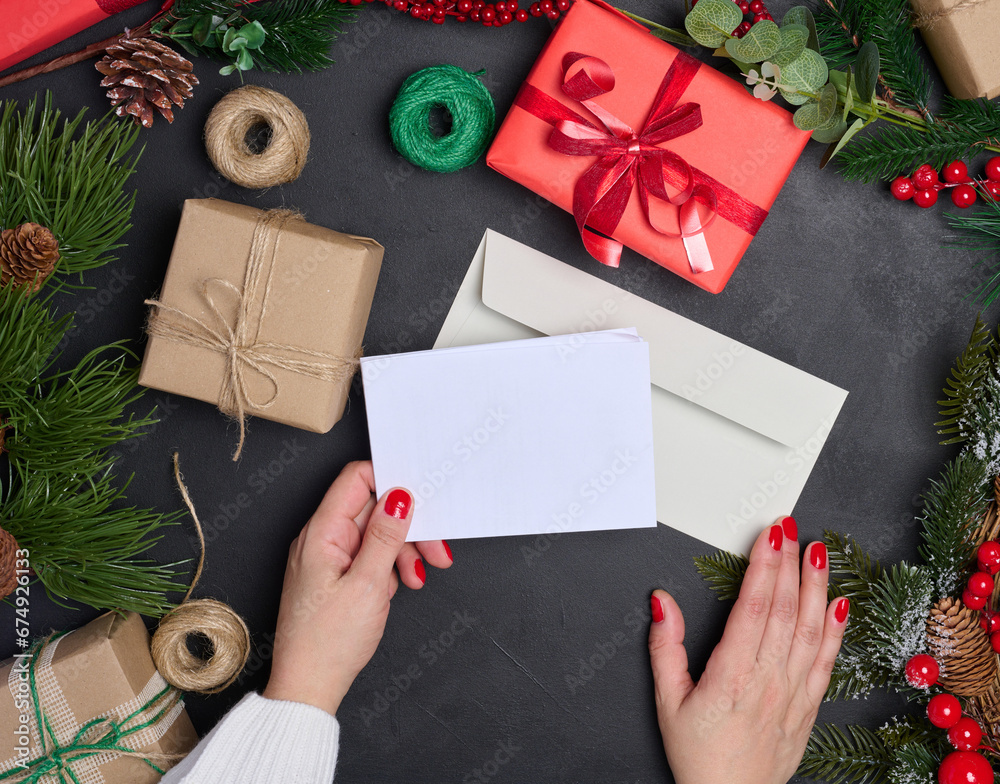 White envelope and Christmas wreath on a black background, top view White envelope and Christmas wreath on a black background, top view
