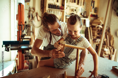 Father and daughter enjoying woodworking together in workshop
