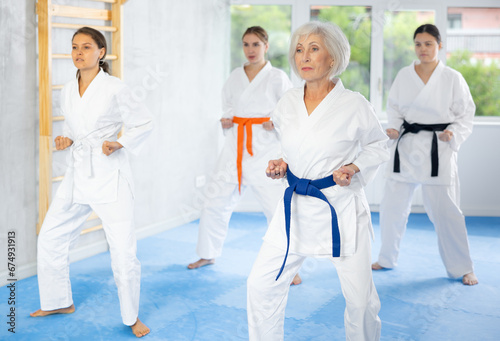 Group of female karatekas practicing karate technique in gym