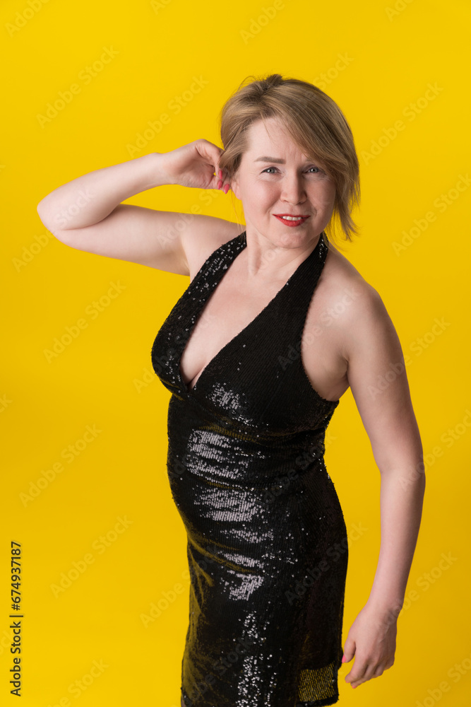Portrait of curvy mature blonde in fashionable black party dress, questionable looking at camera Portrait of curvy mature blonde in fashionable black party dress, questionable looking at camera