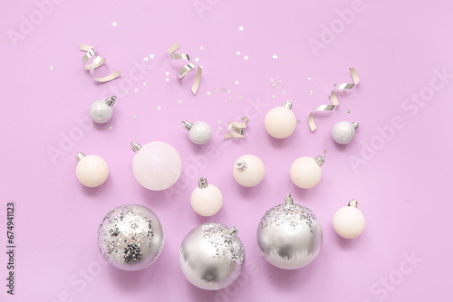 Composition with Christmas balls  ribbons and confetti on lilac background