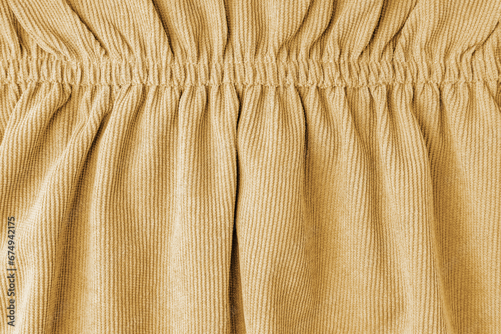 Yellow corduroy fabric gathered with elastic close-up. Velveteen