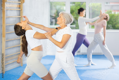 Self-defense class - woman practices blows to the head of an attacking woman