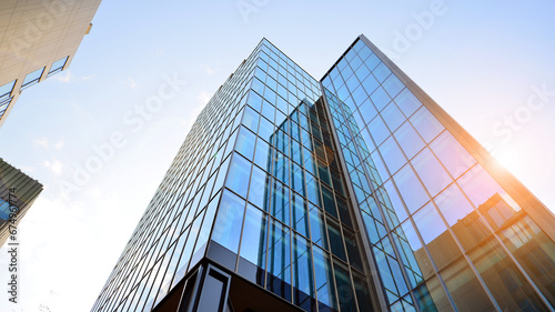 Looking up blue modern office building. The glass windows of building with  aluminum framework.