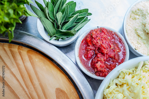 Pizza restaurant bench with pizza ingredients basil tomatoes, onions close up with window background photo