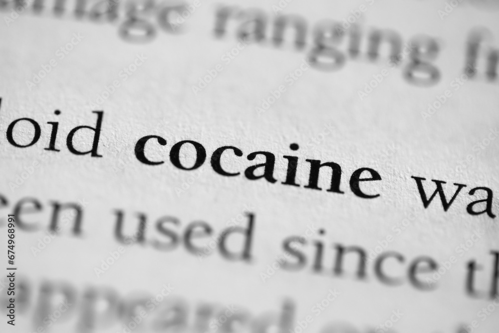 Cocaine, addictive and illegal substance or drug printed in black on white page of book close-up Cocaine, addictive and illegal substance or drug printed in black on white page of book close-up