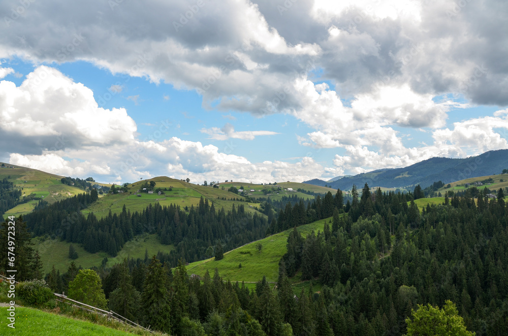 Mountain slopes, trees and clouds in the sky. Amazing landscape view of Ukrainian Carpathian mountains