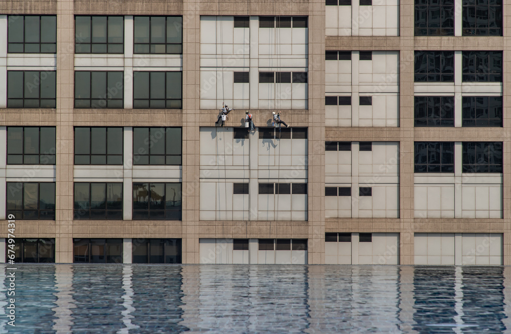Group of workers cleaning windows service on high rise office building. Selective focus.