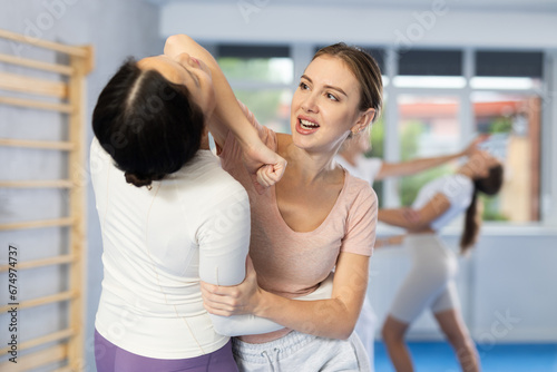 Women train in pairs to strike and reflect blows of enemy. Self-defense training and Krav Maga principles