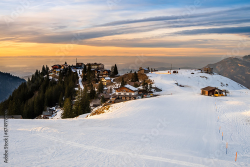 Ski resort and lodges on Klewenalp mountain in Swiss Alps, Switzerland. Popular ski slope and winter sport attraction, winter landscape with snow at sunset