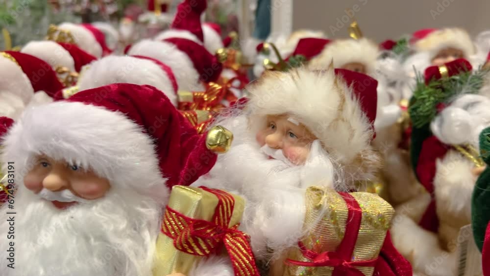 Rows of Santa Claus figurines with gift boxes are sold at the store before Christmas Rows of Santa Claus figurines with gift boxes are sold at the store before Christmas