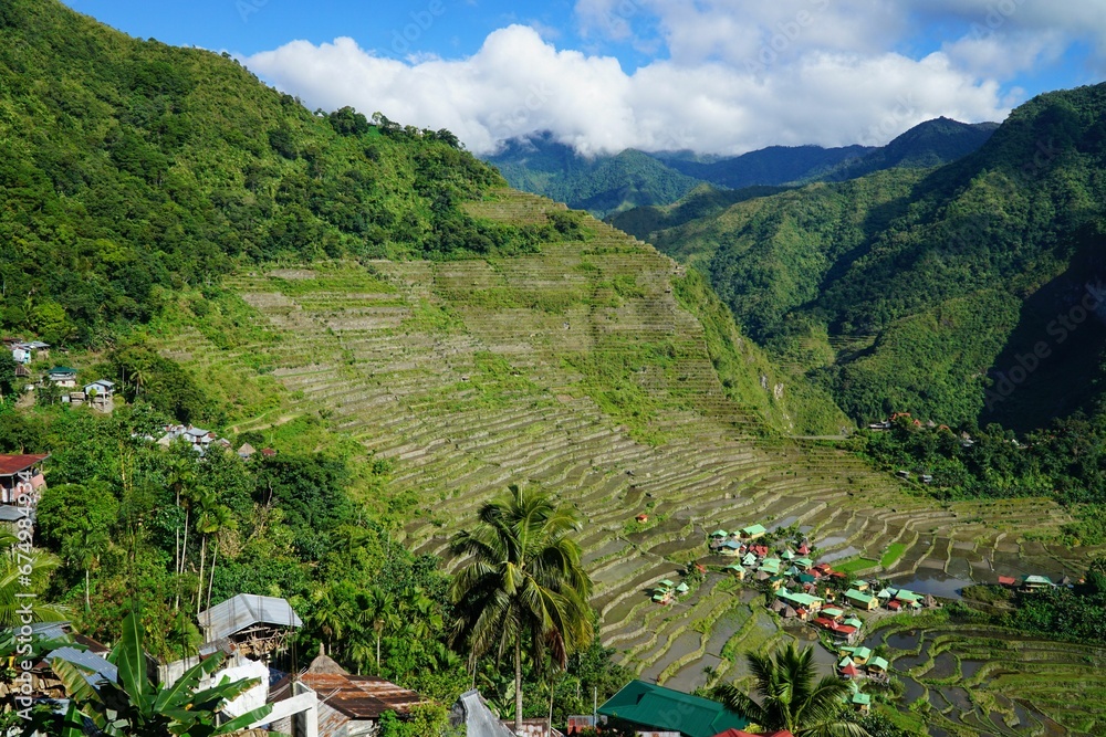 Aerial view of Banaue village in the Philippines, with houses in lush jungle and rice terraces