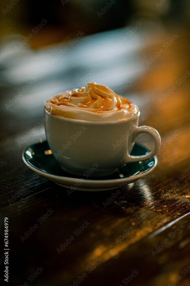 Vertical closeup of a cup of a creamy coffee on the wooden table. Vertical closeup of a cup of a creamy coffee on the wooden table.