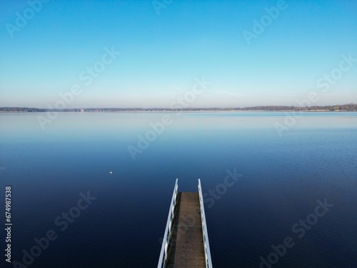 a dock with water and buildings in the background on a sunny day