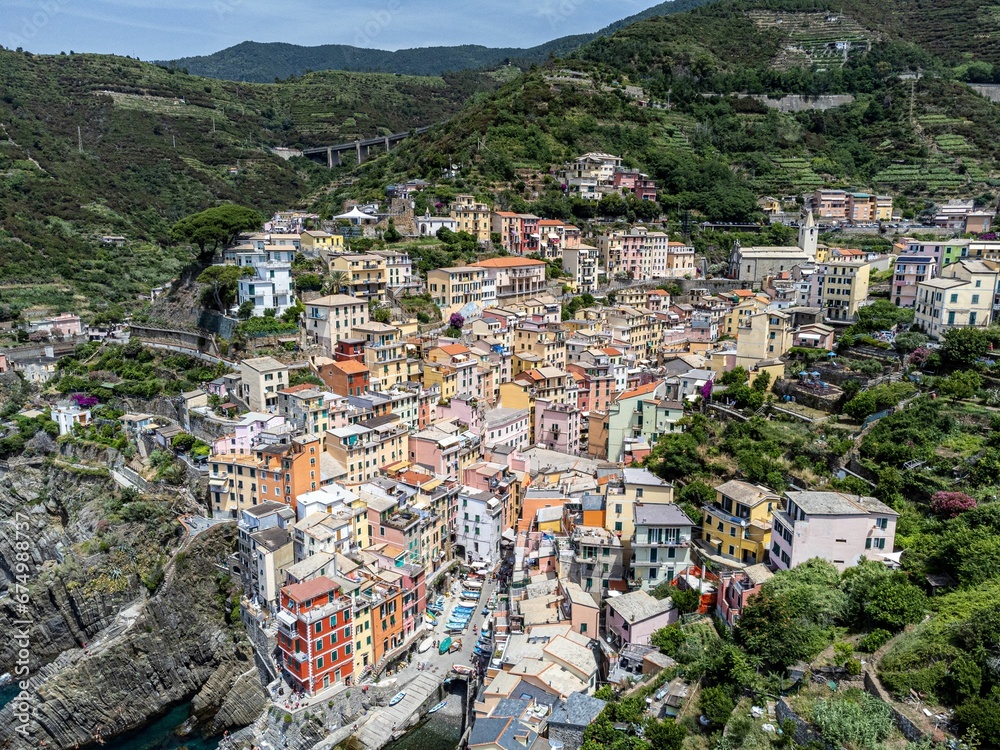 Aerial view of a small town situated on a body of water with mountains in the background in Italy.