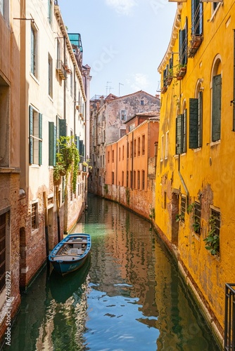 Boat docked in a narrow canal between two buildings in Venice, Italy.