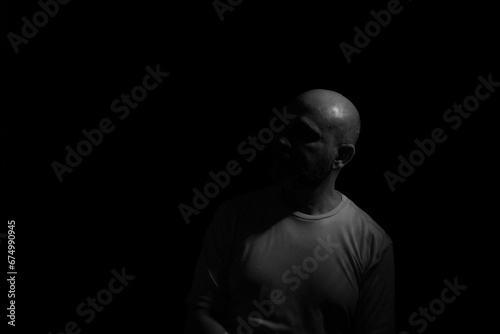 Low light portrait of bearded, bald man. © Thales