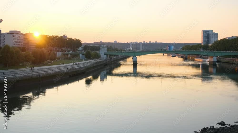 Bridge over a calm river in Rouen, France with the golden sunset shining in the background Bridge over a calm river in Rouen, France with the golden sunset shining in the background