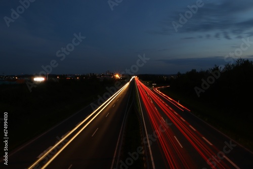 Long exposure shot of glowing car lights on a dark highway