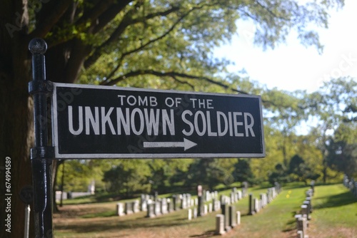 Black and white sign "Tomb of the Unknown Soldier" placed next to a line of graves