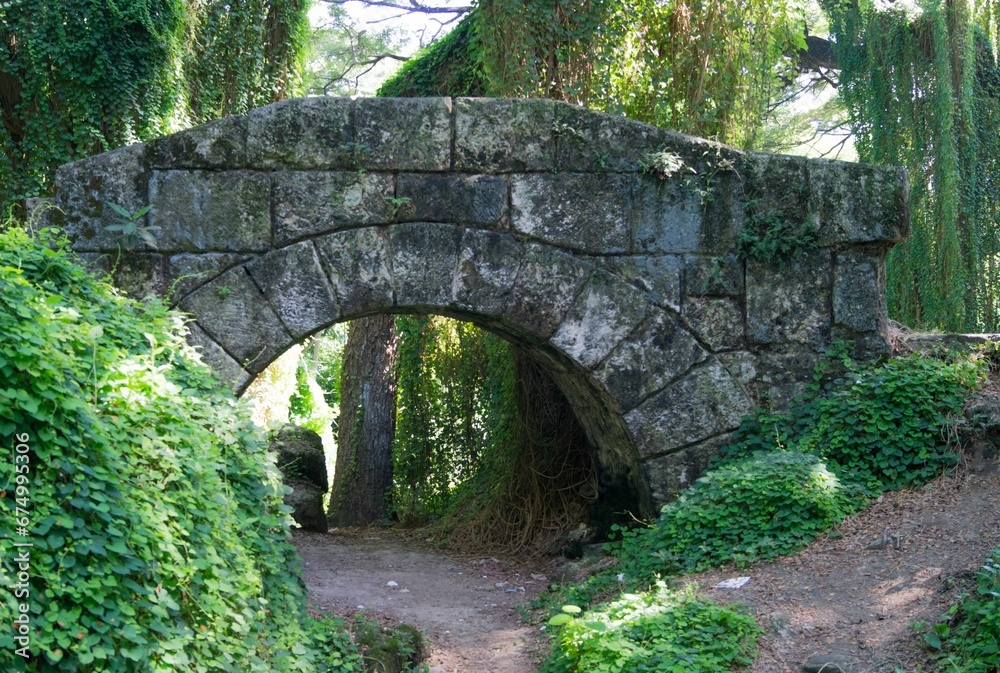 Stone bridge over the dirt road in the park