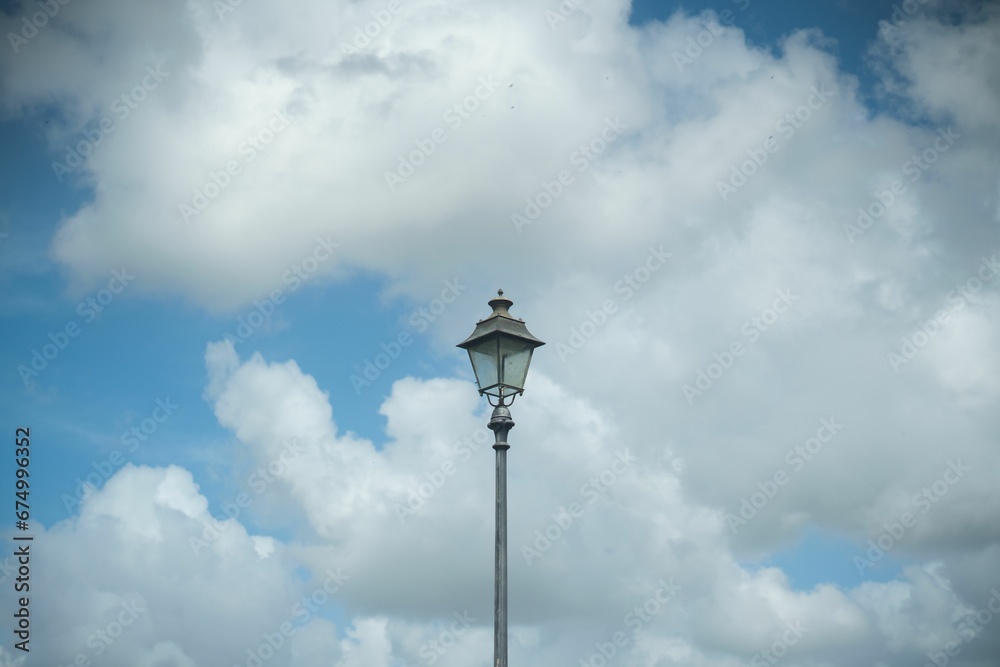 Metal streetlight stands in the city against a backdrop of a vibrant blue sky
