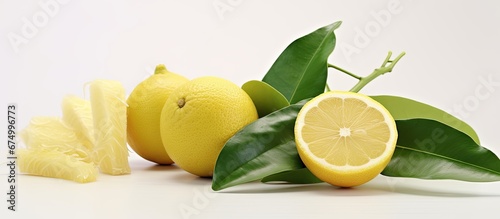 In a white studio background an isolated green leaf rests beside a sweet slice of yellow pomelo a citrus fruit commonly enjoyed in Chinese cuisine photo