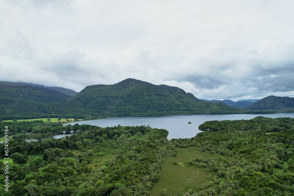 Scenic landscape view of a mountain range with a serene lake and rolling hills in Ireland, Kerry