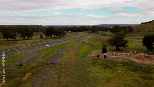 Drone time-lapse view of cars driving on highways between green fields and trees photo
