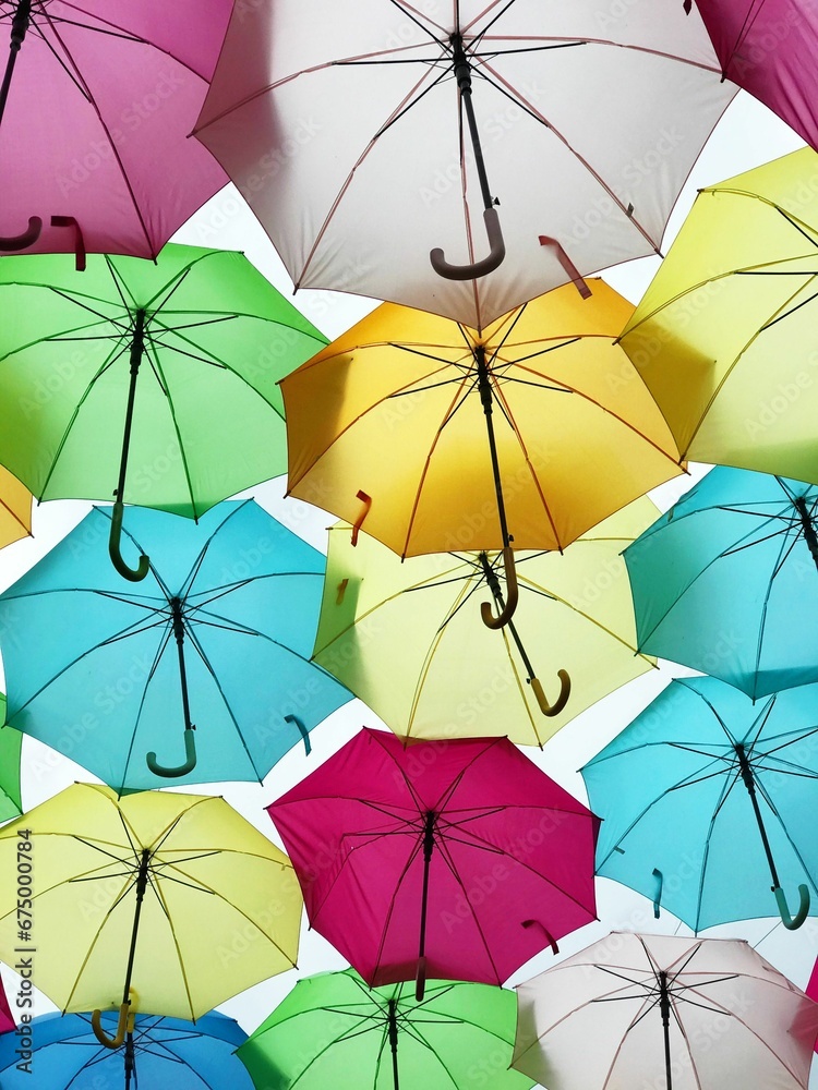 Low-angle shot of a vibrant and eye-catching row of colorful umbrellas Low-angle shot of a vibrant and eye-catching row of colorful umbrellas
