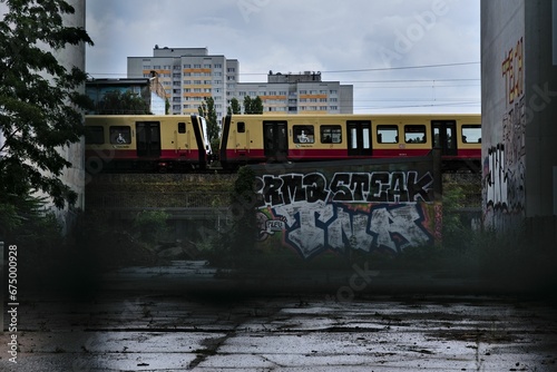 a commuter train going over the top of a tunnel near buildings photo