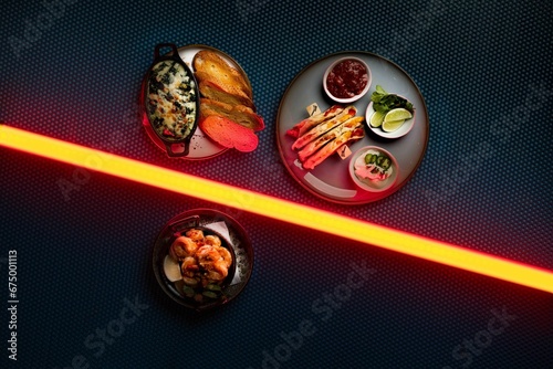 Canvas Print Closeup of various delicious dishes in neon lights
