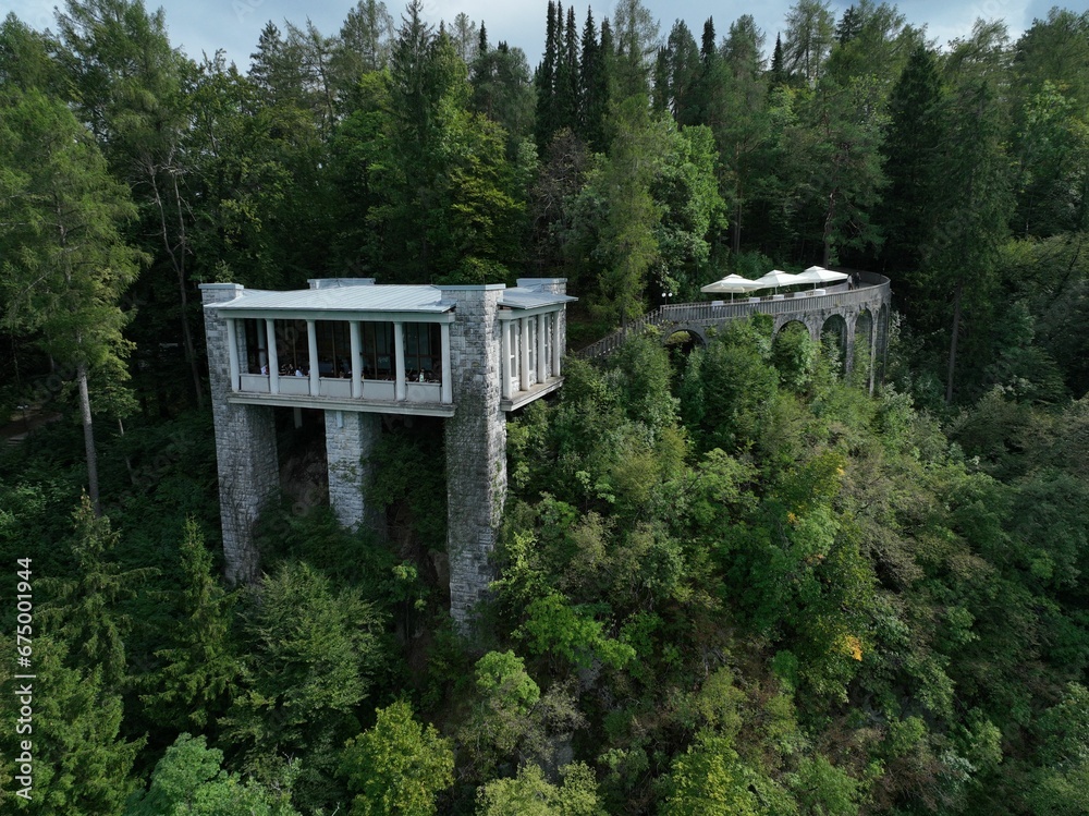 two tall buildings high up over the woods, surrounded by trees two tall buildings high up over the woods, surrounded by trees