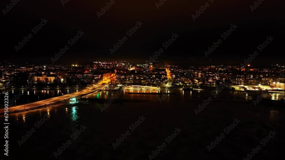 Aerial view rising over the sea, toward the cityscape of Vaasa, night in Finland Aerial view rising over the sea, toward the cityscape of Vaasa, night in Finland