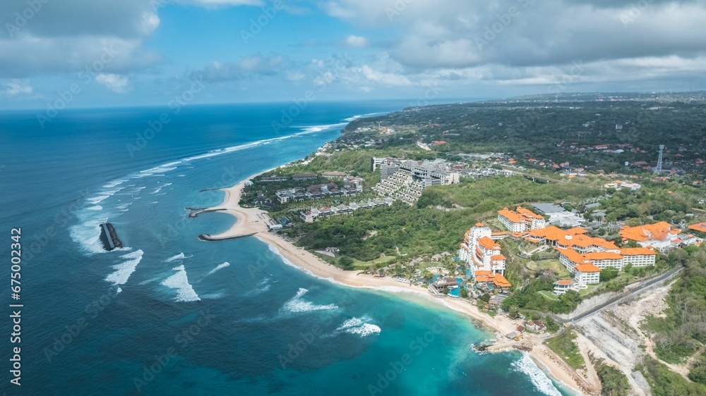 Aerial view of a waterfront area featuring several hotels and resorts in Bali, Indonesia.