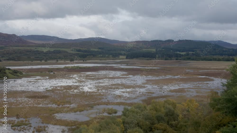 Beautiful view of wetlands with green hills and gray cloudy sky on the horizon Beautiful view of wetlands with green hills and gray cloudy sky on the horizon