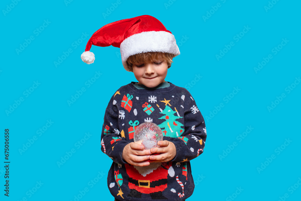 Christmas boy in a holiday clothes. Happy child on a blue background with a Christmas toys. Happy New Year. Merry Christmas! Christmas boy in a holiday clothes. Happy child on a blue background with a Christmas toys. Happy New Year. Merry Christmas!