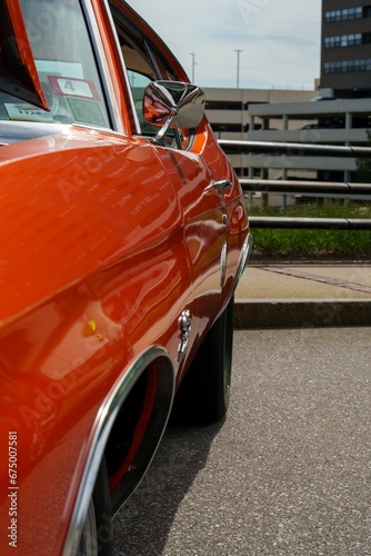 Vertical side view of a red vintage car parked on the street