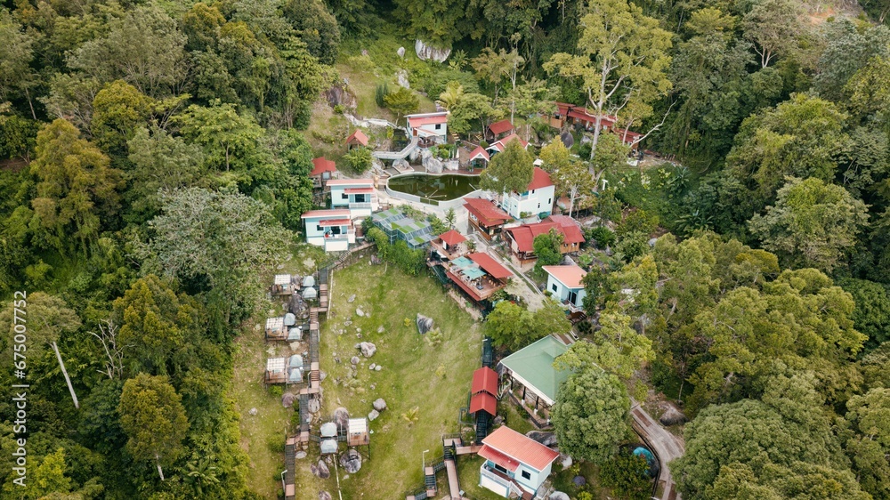 an aerial view of some buildings in the woods on the hill