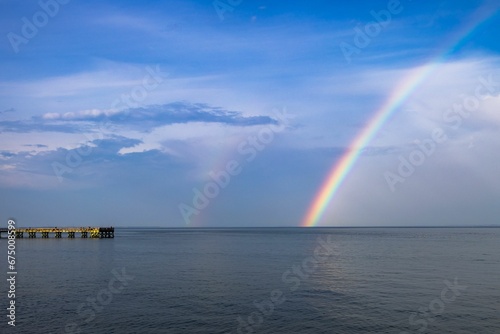 Stunning view of the Downs Park Fishing Pier in Maryland, USA with a rainbow in the backgroudn © Wirestock