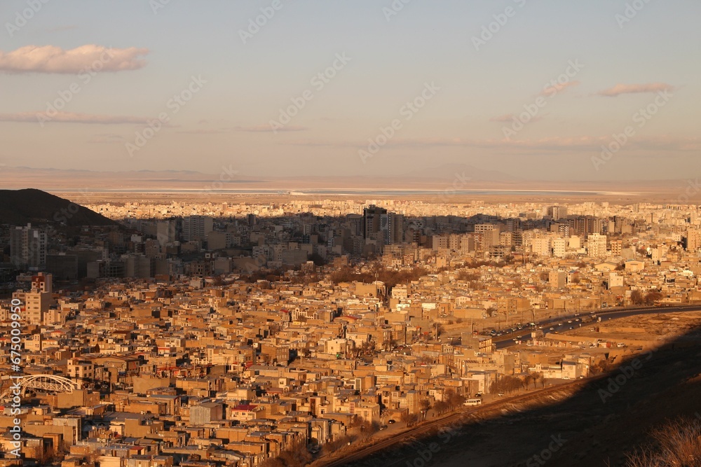 Aerial view of a cityscape with neatly arranged buildings and roads at golden hour