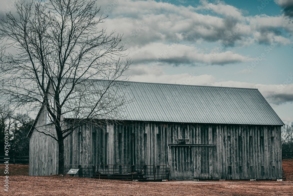 Aged rustic barn in the middle of a lush green grassy field